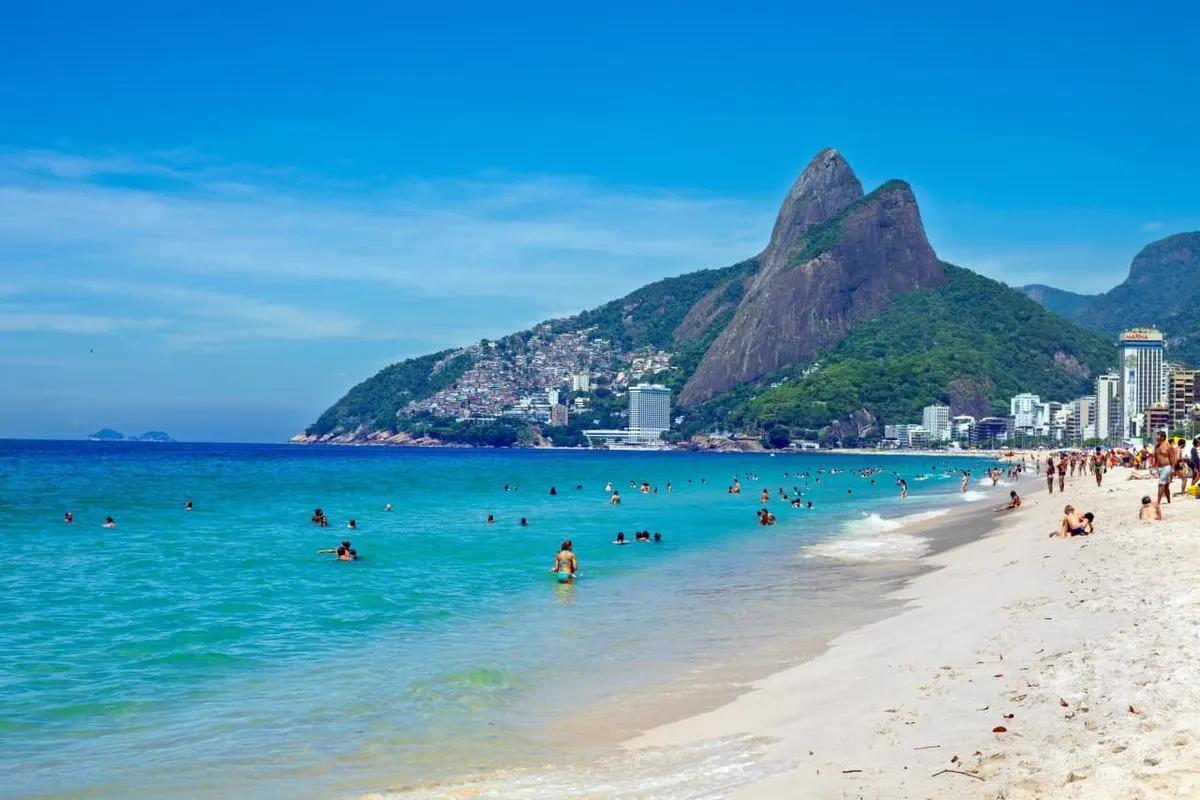 Mar de Ipanema com banhistas e o Morro Dois Irmãos
