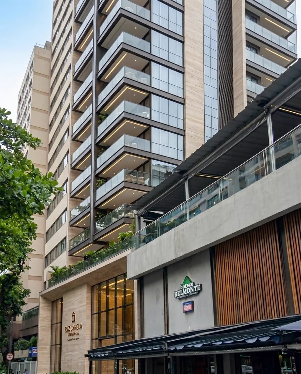 Fachada de edifício residencial RJZ Cyrela com varandas em vidro e iluminação embutida